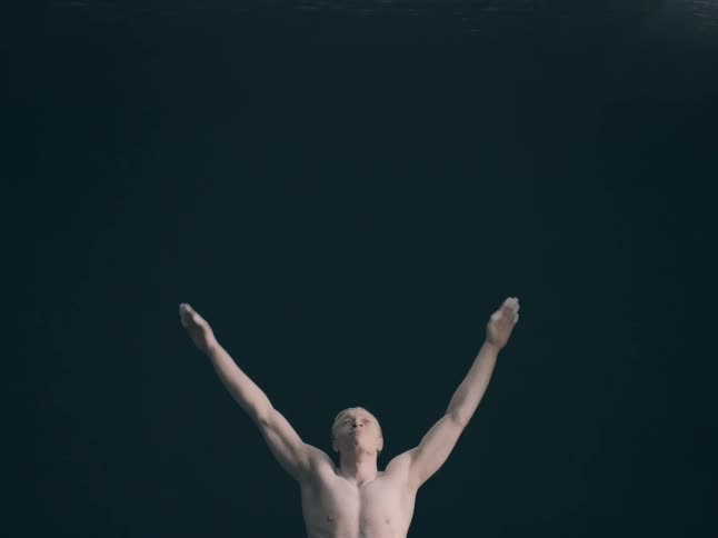 The man raises his arms above his head