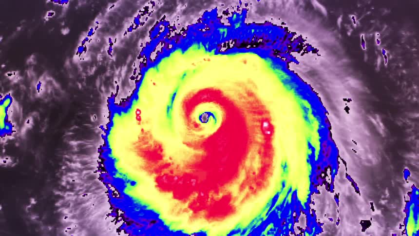 The video displays a vibrant infrared satellite view of a rotating hurricane with a distinct eye clearly visible at its centerthe storms intensity is highlighted by a color gradient ranging from deep red and yellow in the core to blue an