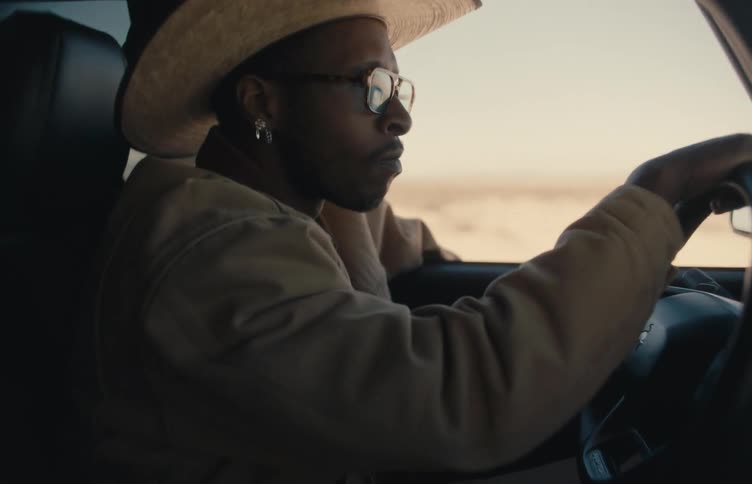 A man driving a car in the desert