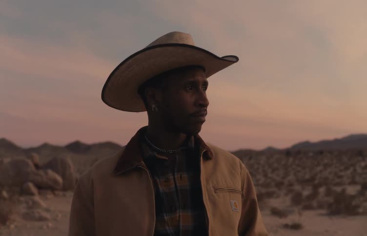 Man stands in the desert under a red sky