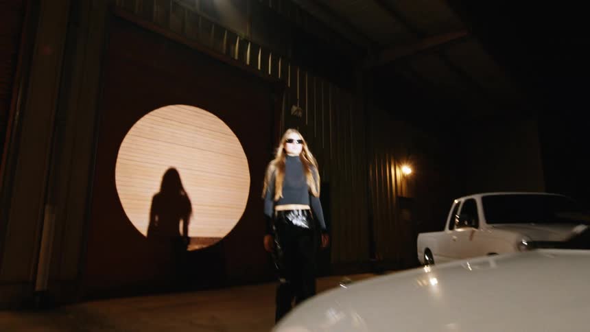 The model walks over to the car