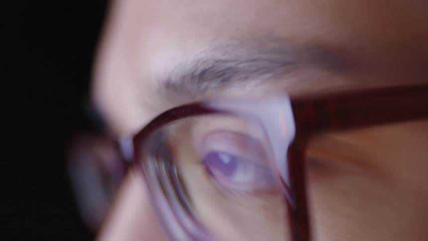 A person looking at a computer screen with glasses