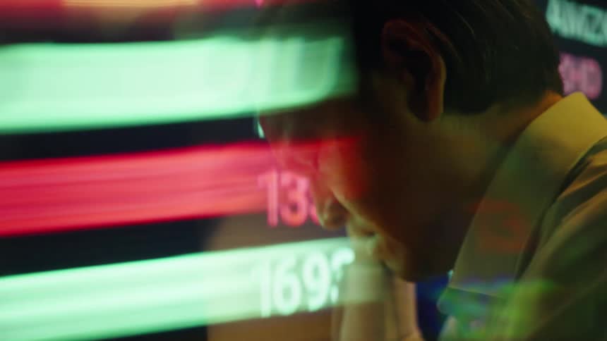 Man thinks while digital financial and stock information is superimposed on his face