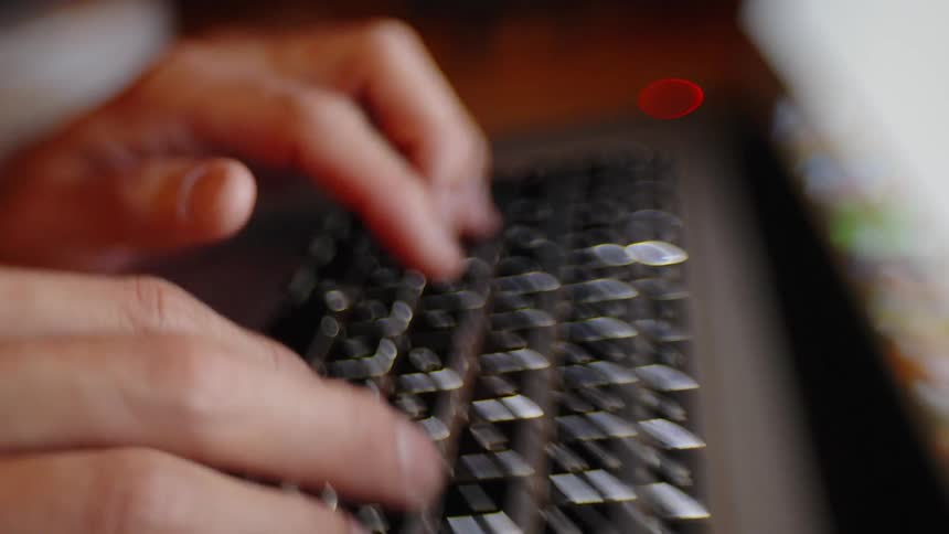 Hands typing on a computer keyboard with shallow depth of field
