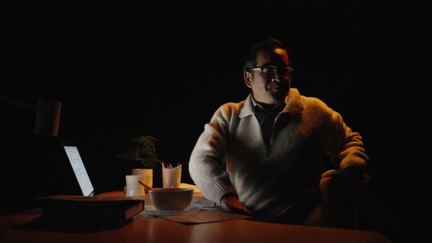 A man sitting at a desk using a laptop