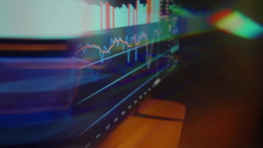 A close up view of financial data charts and graphs displayed on a screen with light distortions