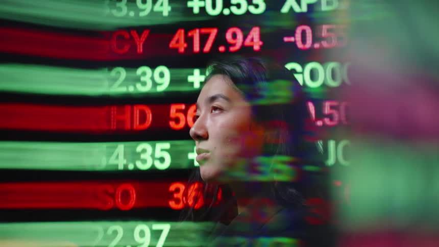 The woman has numbers flashing on a monitor behind her