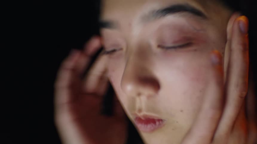 Closeup face with hands placed around eyes