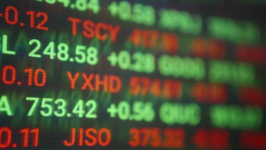 The stock ticker slides across the monitor