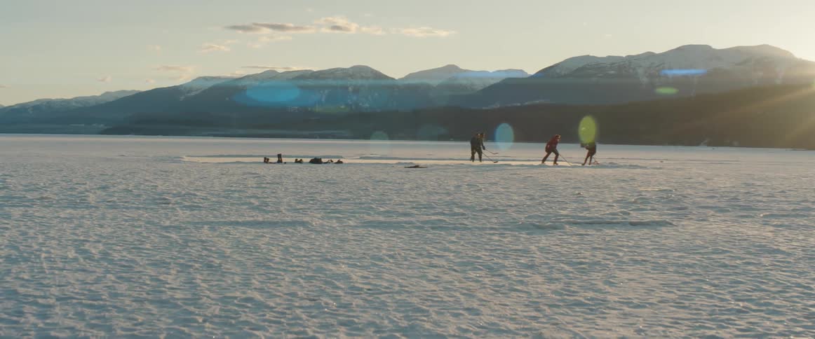 People are playing hockey on the frozen lake