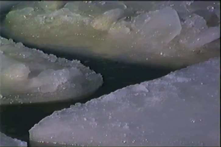 Ice blocks float on dark water