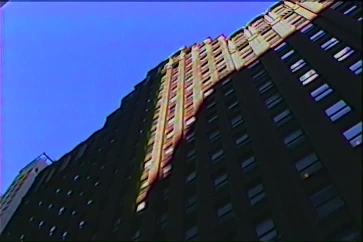 A multistory condo apartment building with sunlight partially illuminating a section at midday