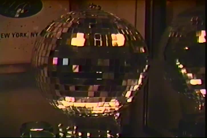 Vintage electronic device with illuminated reels on a table next to a turntable