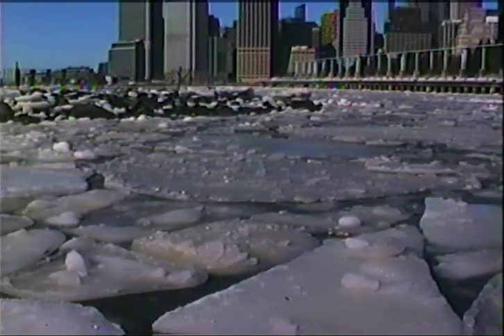 A city skyline with a frozen lake in the foreground at midday