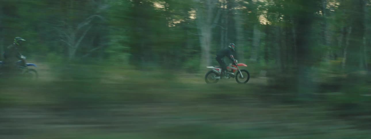 The dirt bikes are doing motocross in the forest