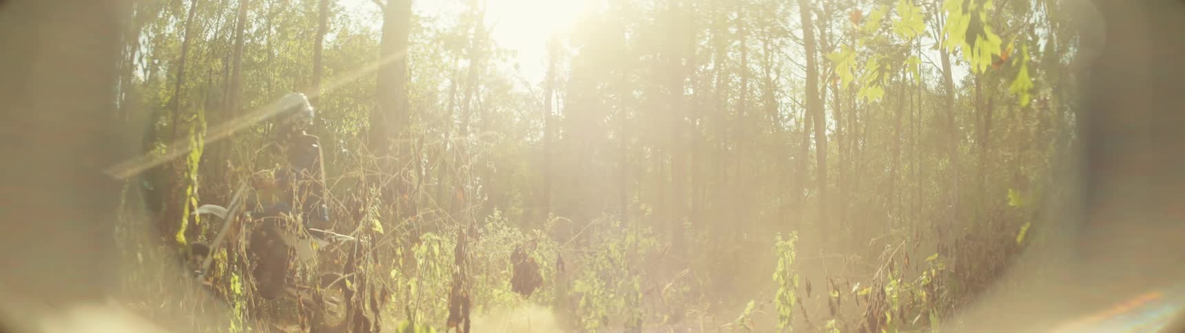 Motorcyclist with offroad motorcycle on a dirt trail among trees