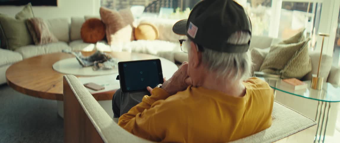 A man sitting in a room using a tablet