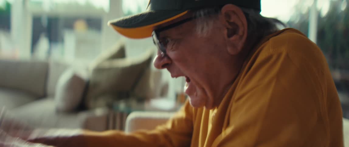 A man cheering while looking at a screen