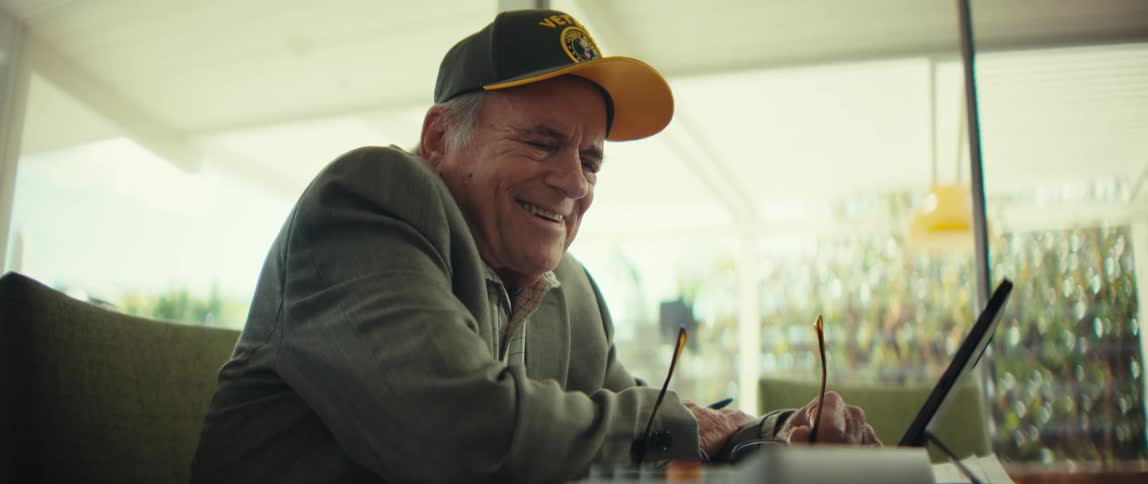 A man hits buttons on a calculator and smiles