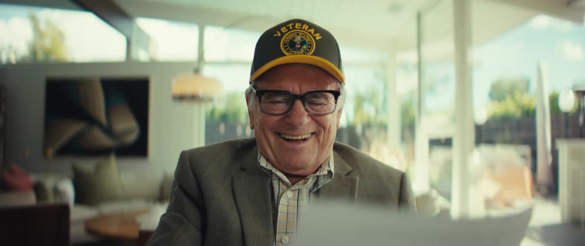 A man reading a paper and laughing