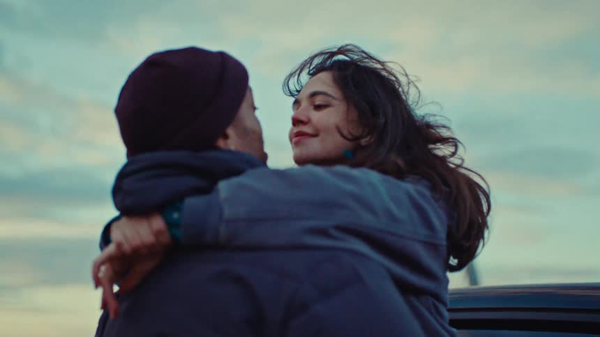 A man and woman are hugging and smiling outside