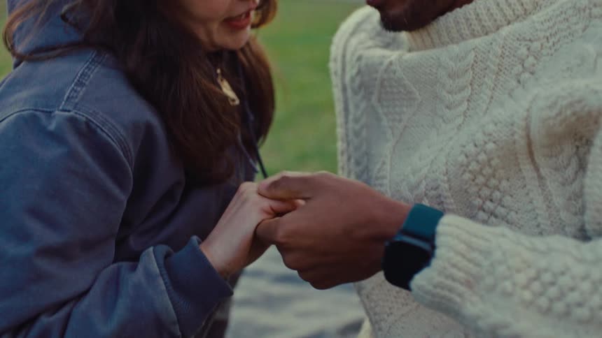 A man and woman sitting outdoors on the grass
