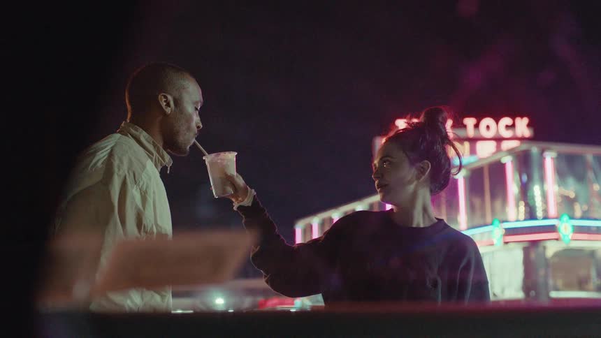 A couple sharing a drink outside