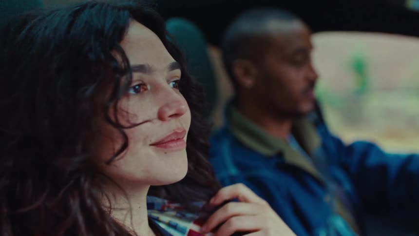 Woman in the passenger seat while a man drives the car