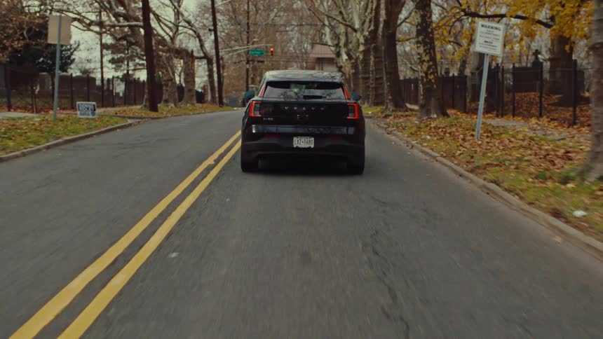 A car driving down a road on a fall day