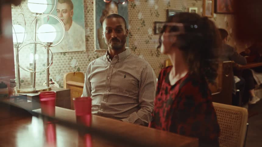 A man and woman are seated close in a restaurant
