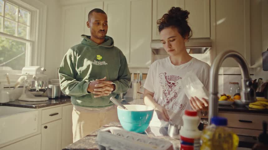 Man and woman preparing a recipe in the kitchen with a bowl and ingredients on the counter