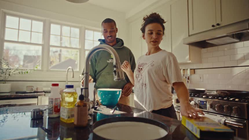 The couple are cooking together in the kitchen
