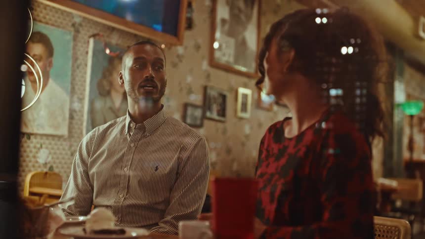 Couple sitting in a restaurant at night talk together