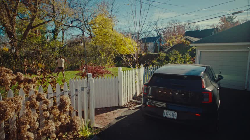 A man and woman are playing in a yard in the suburbs