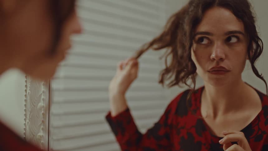 Woman adjusting her hair in front of a mirror