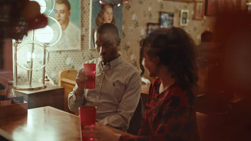 A man and woman having a drink sitting at a table