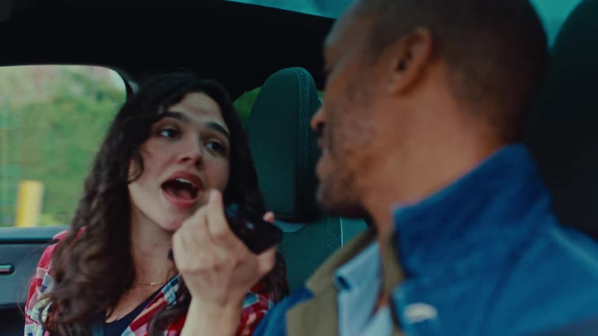 A couple singing in a car while driving