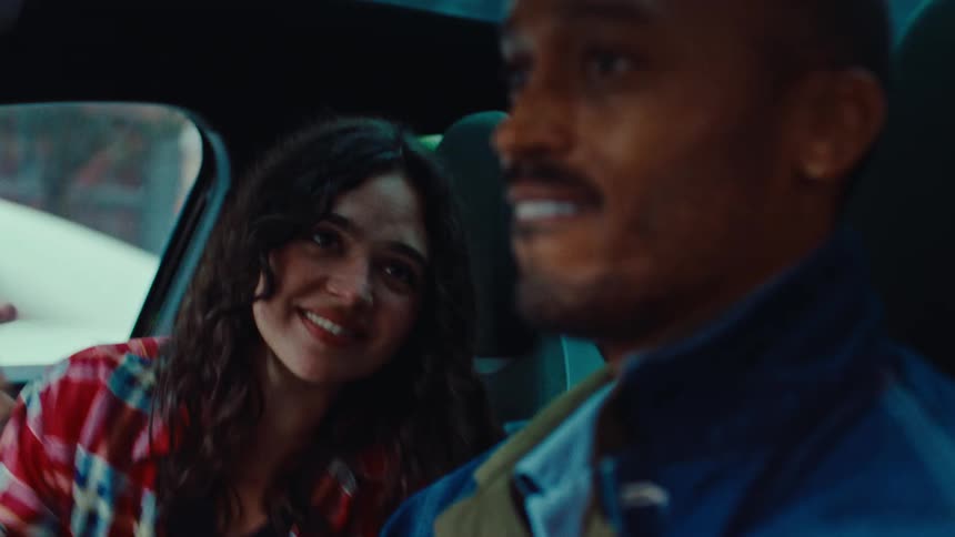 A man and woman singing in a car while driving