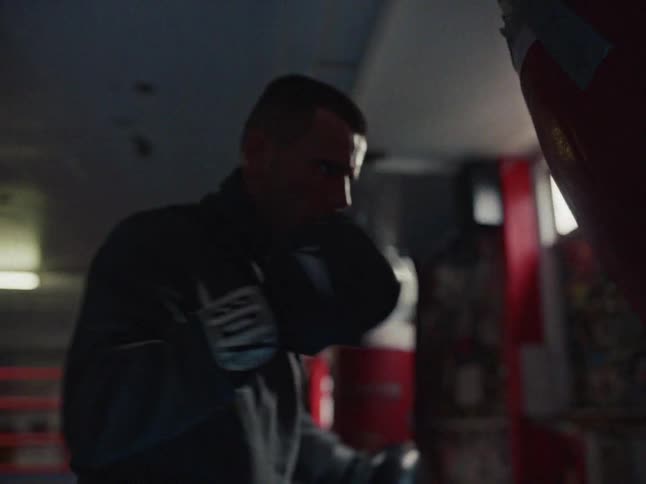 A man is practicing boxing in a gym