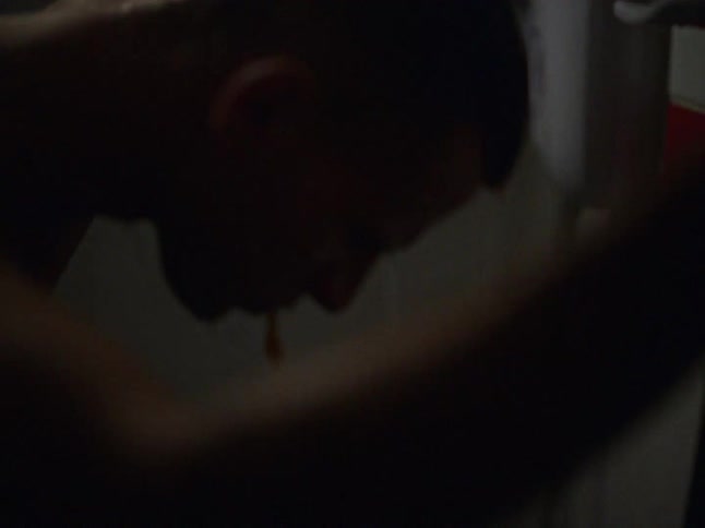 A man taking a shower while coughing up blood