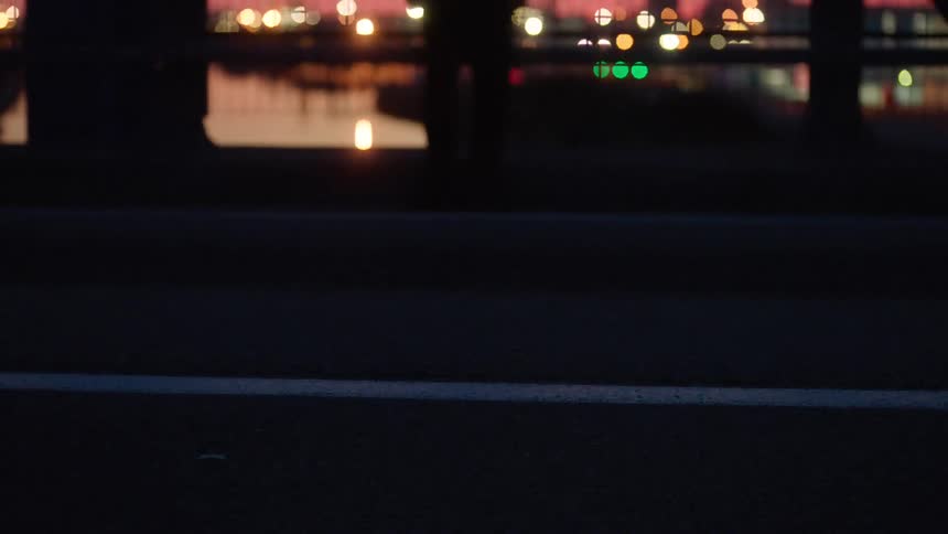 A person is standing outside looking over the water in a city