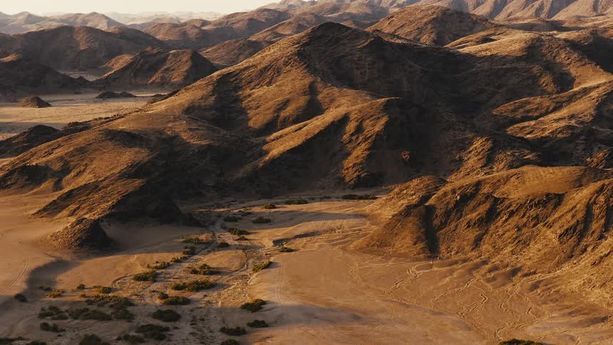 A mountainous formation and hills in the wilderness at midday