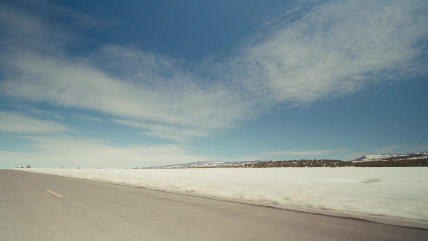 The highway runs through the snow covered fields