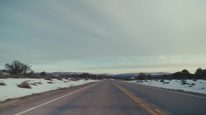 The desert is covered in snow by the highway