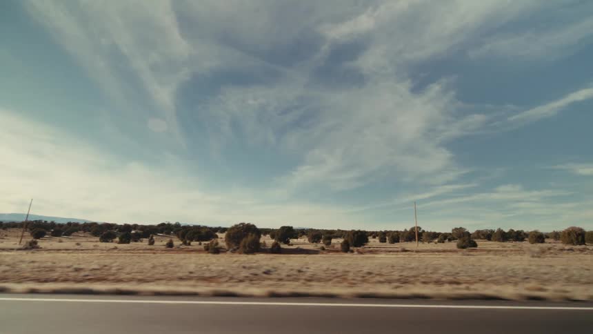 Traveling along a road and the blue sky has clouds stretched across it