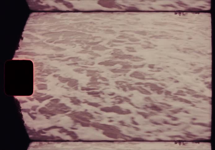 A moving organic line where the white sea foam meets the darker sand it shifts dynamically across the frame as the water advances and retreats