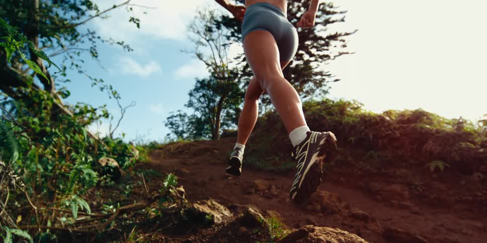 A woman running up a trail