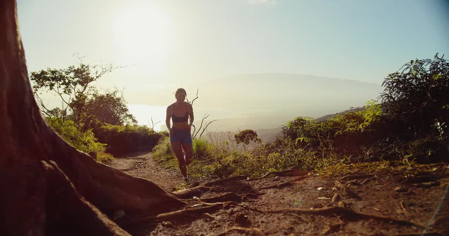 A woman running down a trail