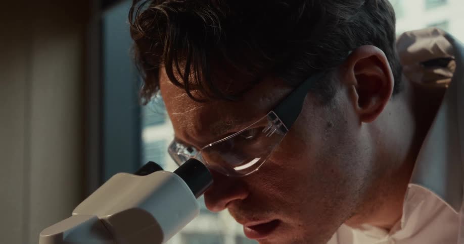 The man is looking through a microscope