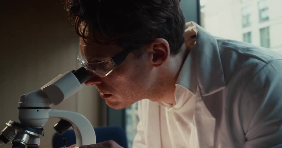 The scientist is using a microscope